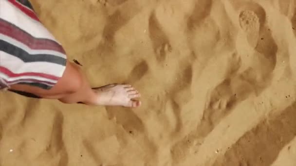 Top view of faceless female legs barefoot walking on sandy beach sunny summer day. Tracking video shot of unrecognizable woman going on sand bare feet hot weather. Holidays vacation travel trip - Footage, Video