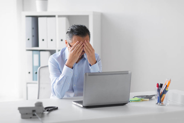 stressed businessman with laptop working at office - Valokuva, kuva