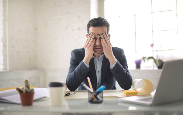 Zestresowany mężczyzna pracujący przy biurku - Zdjęcie, obraz