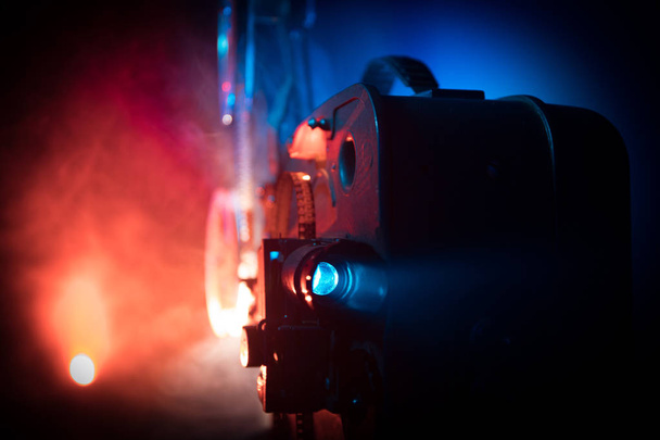 霧と光と暗い背景に古いヴィンテージ映画プロジェクター。映画製作のコンセプト選択的フォーカス - 写真・画像