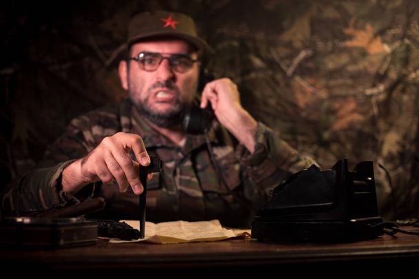 Masada oturan kötü diktatör. Kızgın komünist genel oturma Merkez veya karanlık odada Küba Komutan. Studio dekorasyon - Fotoğraf, Görsel