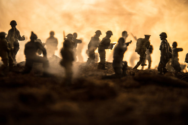 Concepto de guerra. Siluetas militares peleando escena en el fondo del cielo niebla de guerra, Soldados de la Guerra Mundial Siluetas debajo del horizonte nublado Por la noche. Escena de ataque. Vehículos blindados. Batalla de tanques. Decoración
 - Foto, imagen
