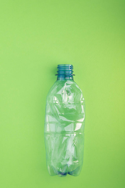 Crashed plastic bottle on green background. Plastic utilisation concept. Ecological problem, global environment. - Foto, immagini