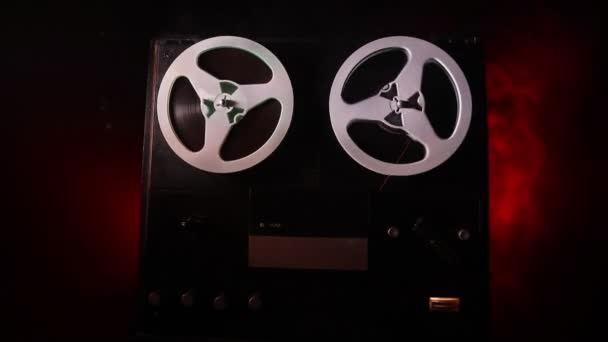 Carretel vintage velho para reel player e gravador em fundo enevoado tonificado escuro. Analog Stereo Open Reel Tape Deck Recorder Player com bobinas. Foco seletivo
 - Filmagem, Vídeo