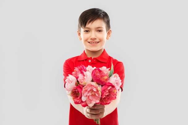 smiling boy with peony flowers - Foto, afbeelding