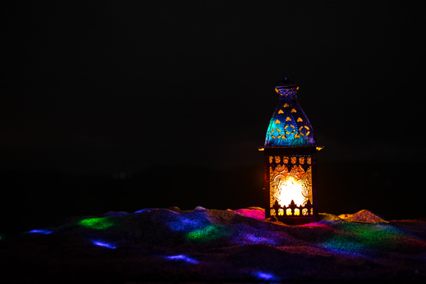 夜に燃えるキャンドルが輝く装飾アラビアランタン。お祝いのグリーティングカード、イスラム教徒の聖なる月への招待ラマダーン・カレーム. - 写真・画像