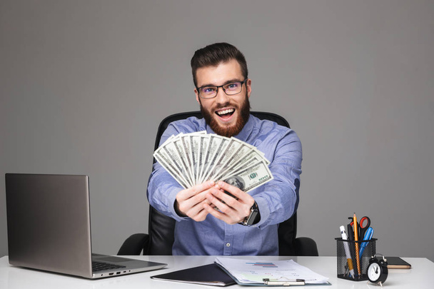 Happy bearded elegant man in eyeglasses showing money - Фото, зображення