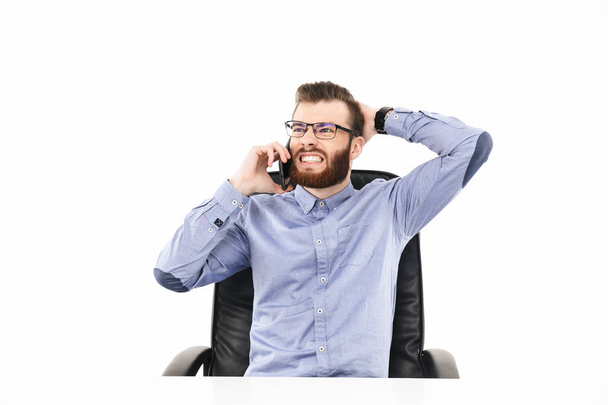 Displeased bearded elegant man in eyeglasses talking by smartphone - Foto, immagini