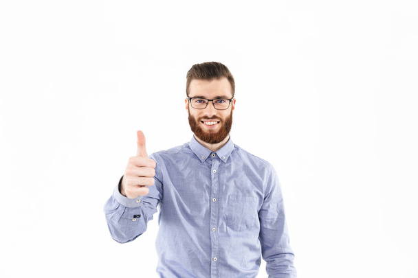 Smiling bearded elegant man in eyeglasses showing thumb up - 写真・画像