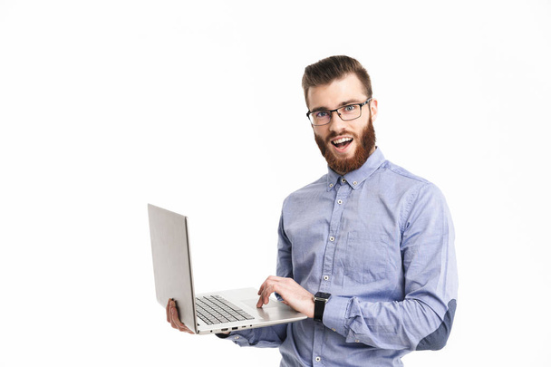 Smiling bearded elegant man in eyeglasses holding laptop computer - 写真・画像