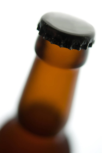 Frasco de cerveja com tampa preta isolada sobre fundo branco
 - Foto, Imagem