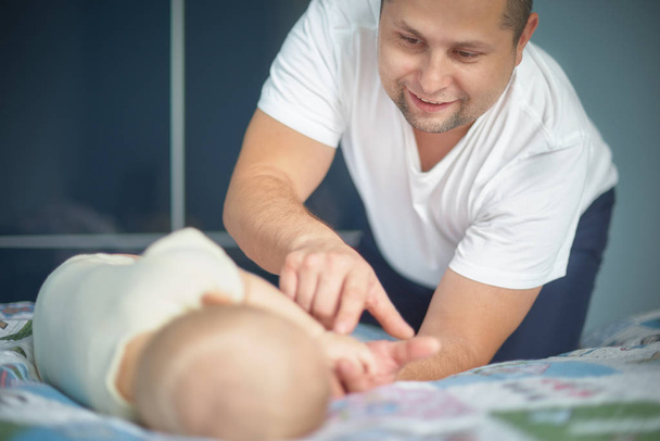 young dad holds the hand of his newborn baby. Hand in hand. Little baby hand in dad s big hands. Together love family nursery healthcare and medical father s day concept - Photo, Image