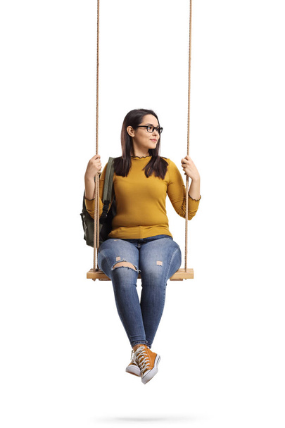 Female student on a swing looking away isolated on white background - Zdjęcie, obraz