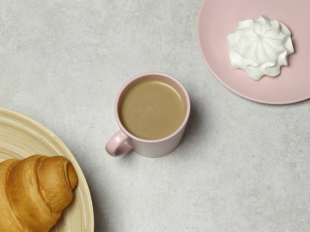 The pink cup of cappuccino with marshmallow and croissant on the granite background - Photo, Image