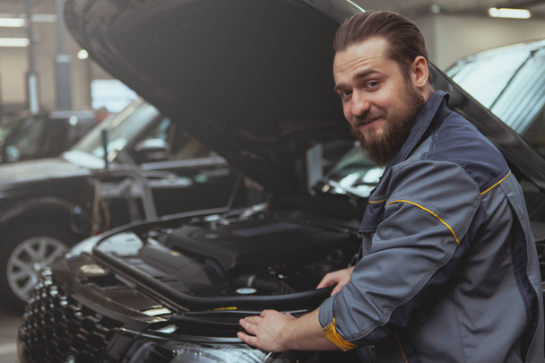 Bearded mechanic working at car service station - Photo, Image