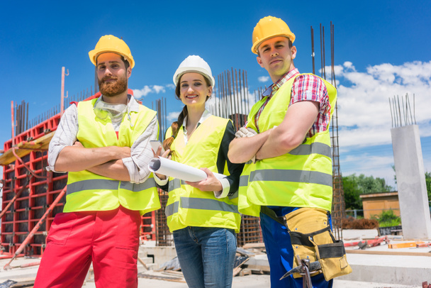 Portrait de trois jeunes employés confiants et fiables sur le chantier
 - Photo, image