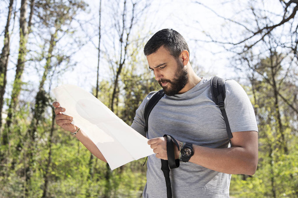 Male hiker using a map to locate the destination - Foto, imagen