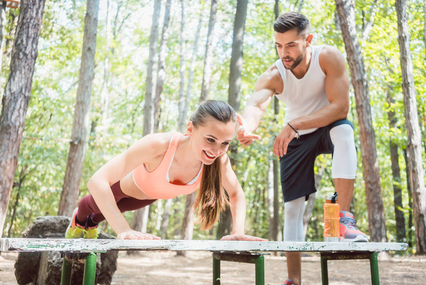 Sporty woman doing push-up in an outdoor gym - Foto, imagen