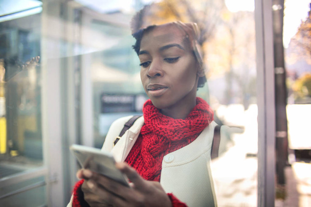 Hermosa mujer afroamericana mensajes de texto en el teléfono inteligente
  - Foto, Imagen