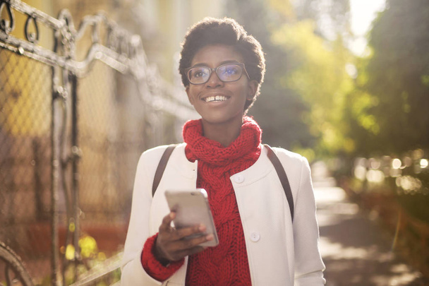 hermosa mujer afroamericana sosteniendo teléfono inteligente
  - Foto, Imagen