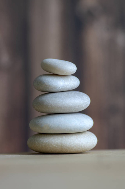 Harmony and balance, cairns, simple poise stones on white background, rock zen sculpture, five white pebbles, single tower - Zdjęcie, obraz