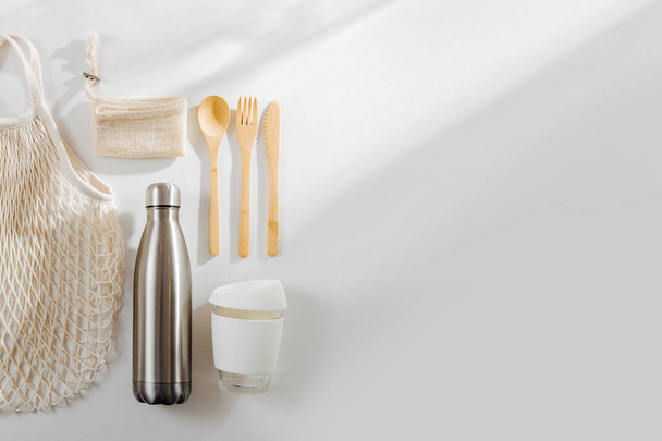 Set of Eco friendly bamboo cutlery, eco bag  reusable coffee mug  and  water bottle. Sustainable lifestyle.  Plastic free concept. - Photo, image