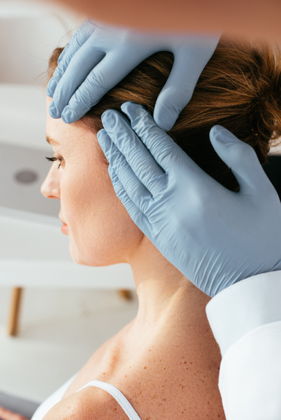nyírt kilátás bőrgyógyász a latex kesztyű vizsgálata haj beteg klinikán  - Fotó, kép