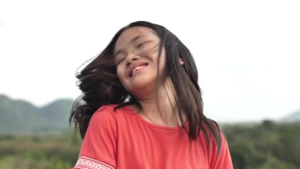 close up retrato de alegre asiático menina sorrindo feliz brincalhão aproveitando dia no hillside parque
 . - Filmagem, Vídeo