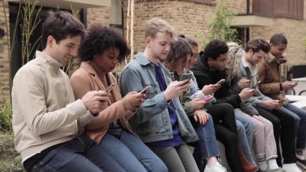 Vícerasová skupina přátel s telefony Smartphone ve městě - Záběry, video