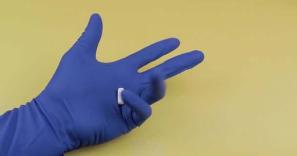 Elinde kauçuk steril tıbbi eldiven giymiş bir oval beyaz hap - Video, Çekim