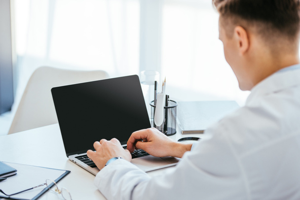 selective focus of doctor using laptop with blank screen  - Фото, изображение