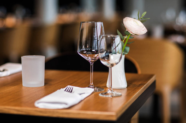 Bicchieri vuoti con tessuti e rosa rossa nel ristorante
 - Foto, immagini