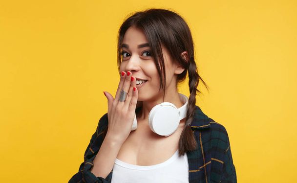 Překvapený ženský teenager vyjadřuje velký zmatek, drží ruku na ústa, zírá na kameru, izolované růžové pozadí. - Fotografie, Obrázek