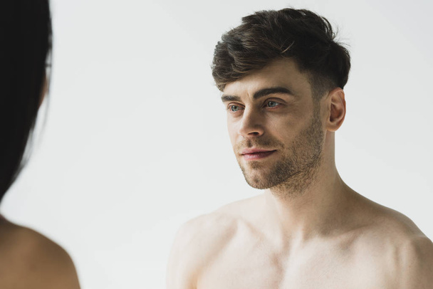 handsome, pensive shirtless man tenderly looking at girlfriend on grey  - Photo, Image