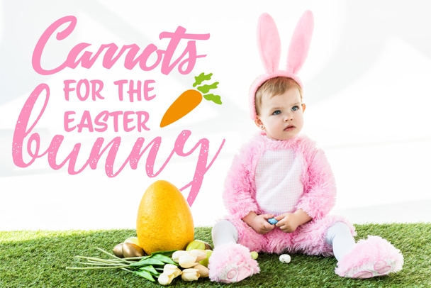 lindo bebé en traje de conejo sentado cerca de coloridos huevos de pollo, tulipanes y huevo de avestruz amarillo con zanahorias para la ilustración de conejo de Pascua
 - Foto, Imagen