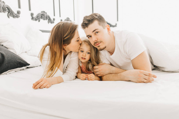  happy family plays and enjoys in bed       - Valokuva, kuva