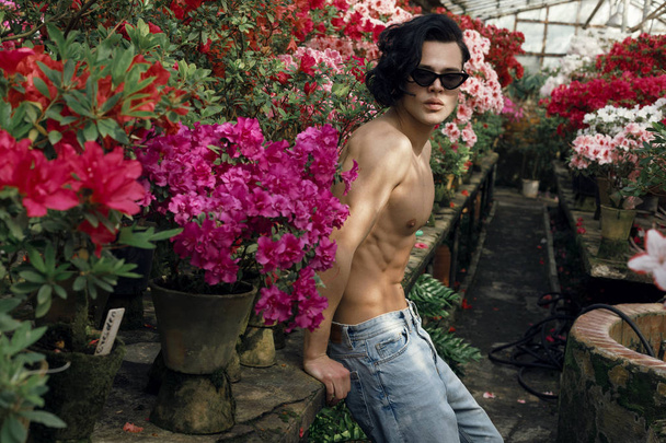 Sexy serious shirtless young man with long trendy hair in black stylish sunglasses - Photo, image