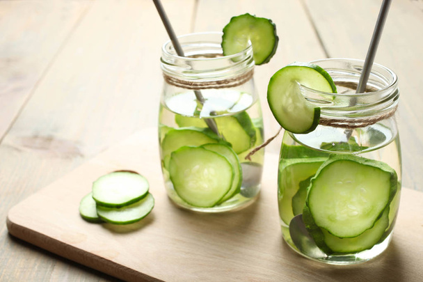 Pot met water en komkommer - Foto, afbeelding