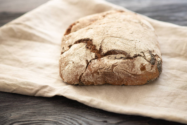 homemade bread is lying on a wooden table - Φωτογραφία, εικόνα
