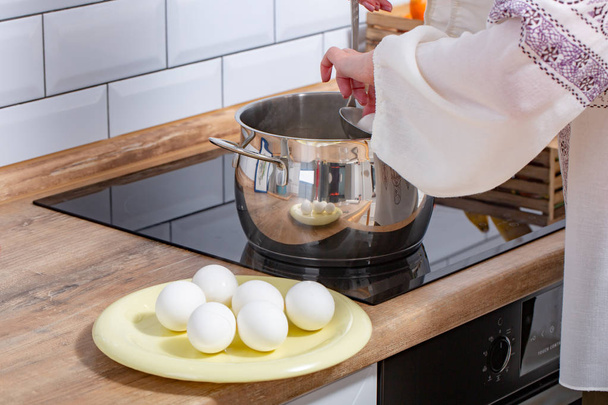 Cooking chicken eggs in pot on electric stove - Photo, Image