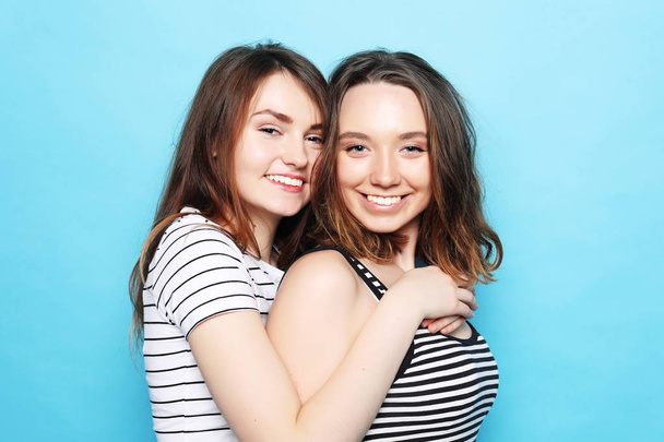 two pretty teen girlfriends smiling hugs and having fun - 写真・画像