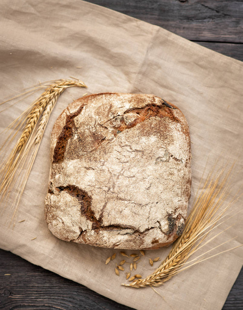 homemade bread is lying on a wooden table - Fotoğraf, Görsel