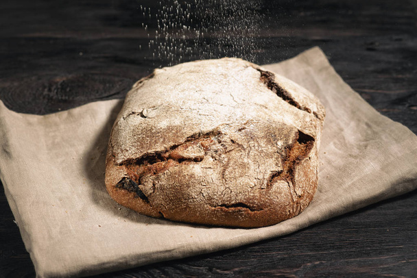 homemade bread is lying on a wooden table - Φωτογραφία, εικόνα