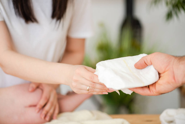 Male hand give diaper for female with baby - Φωτογραφία, εικόνα