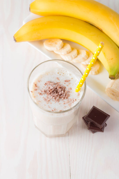 Świeży wykonane Banana Chocolate Smoothie na drewnianym stole. Selektywny fokus. Koktajl z migdałami. Dieta białko. Zdrowe jedzenie i picie koncepcja. - Zdjęcie, obraz