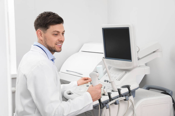 Sonographer operating modern ultrasound machine in clinic - Foto, afbeelding