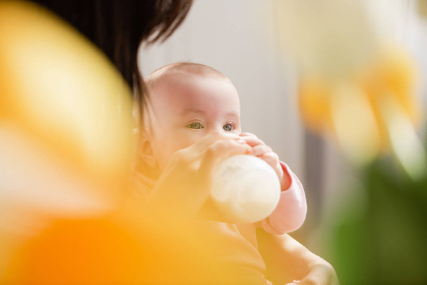 Vauva maitopullo keltainen kukka bokeh
 - Valokuva, kuva