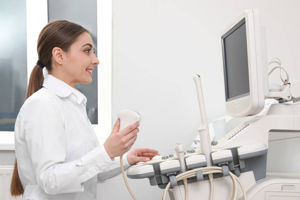 Professional sonographer using modern ultrasound machine in clinic - 写真・画像