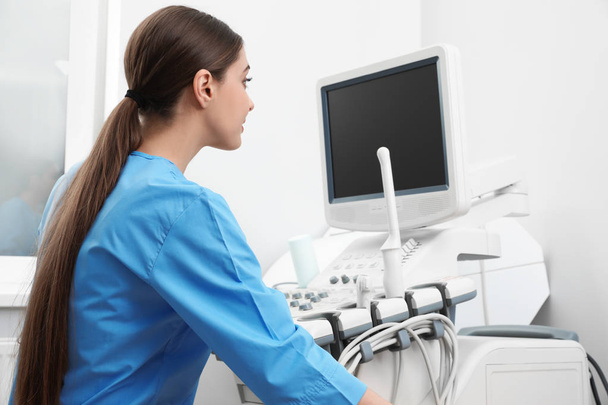 Sonographer operating modern ultrasound machine in clinic - Zdjęcie, obraz