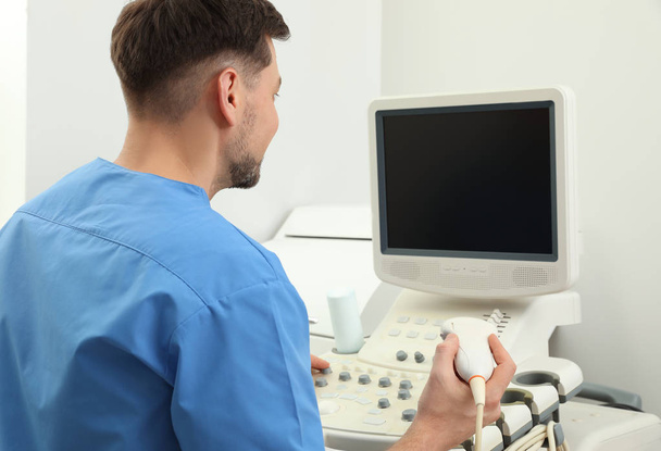 Sonographer operating modern ultrasound machine in clinic - 写真・画像